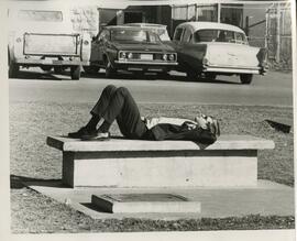 Person sleeping on a bench outside, 1968.