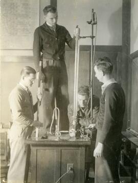 Students surrounding large physics equipment