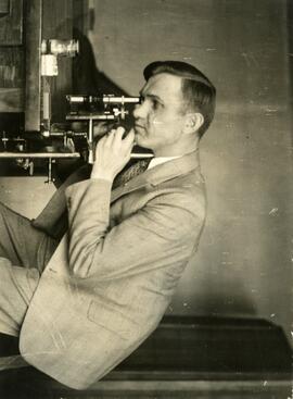 Person sitting near physics equipment