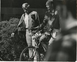 two guys talking over bicycle