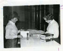 Checking out library books to student, circa 1970.