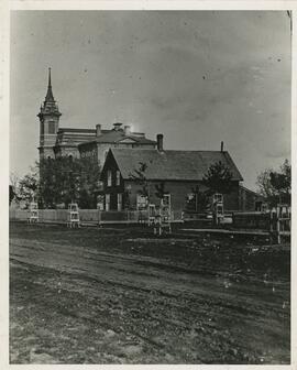 View of a house on cascade avenue, with the River Falls Normal Building in the background