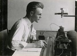 Student looking into piece of equipment
