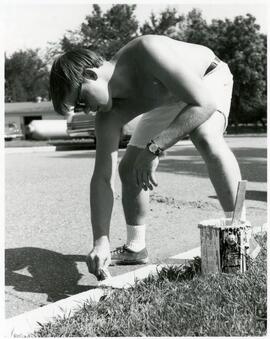 Student painting the curb, 1969.