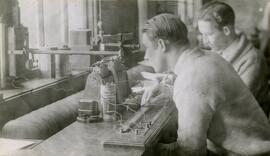 Students looking into piece of equipment