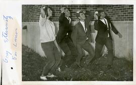 Students in suits holding beanies on heads, 1965