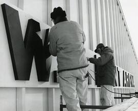 Installing sign on Hunt Arena, 1972.