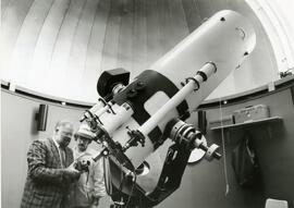 Pair looking into large telescope