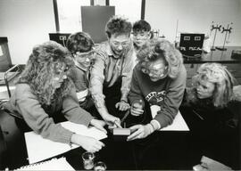Many students wearing goggles looking at equipment