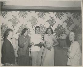 Group standing together laughing, no date.