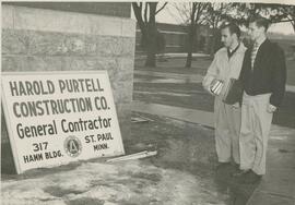 Students reading a contractor sign outside of South Hall, 1954.