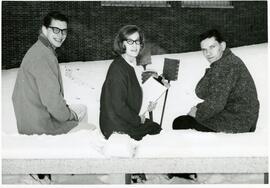 Students seated on a snow covered bench.