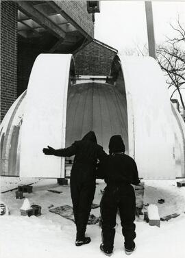 Two people inspect the observatiory dome before installation, circa 1970.