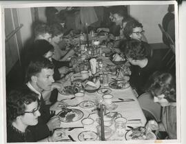 Group eating dinner at a long table, no date.