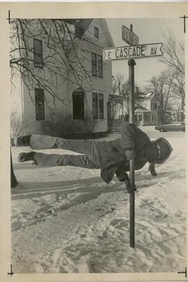 Hanging on to a Street Sign.