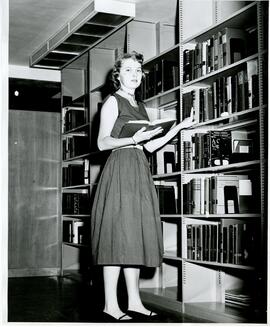 Woman pulling books in the library.