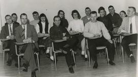 Students and Faculty seated at desks.