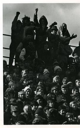 Spectators watching from the bleachers, 1970s.