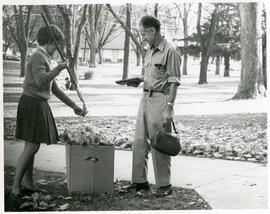 Herman Fritsch watches as a student picking up leaves, 1967.