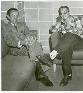 Two people seated in a lounge on campus.