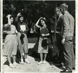 Students outside holding beanies on heads, 1950-1970