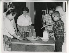 Students gathered around a table, no date.