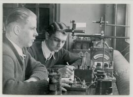 Pair taking notes and using equipment
