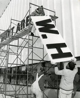 Installing sign on Hunt Arena, 1972.