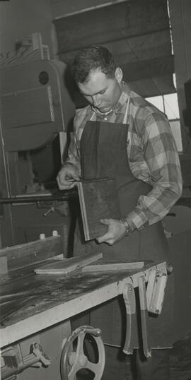 Student holding pieces of wood in classroom, 1969