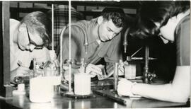 Students with beakers writing notes