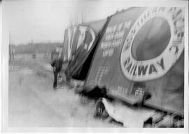 Hudson: railroads, George Joyce standing by wrecked North Pacific boxcar, undated